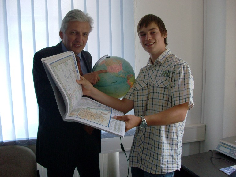 Johann Hientzsch zeigt eine Karte von Nevade während Manfred Kolbe auf dem Globus das Ziel der Reise zeigt.